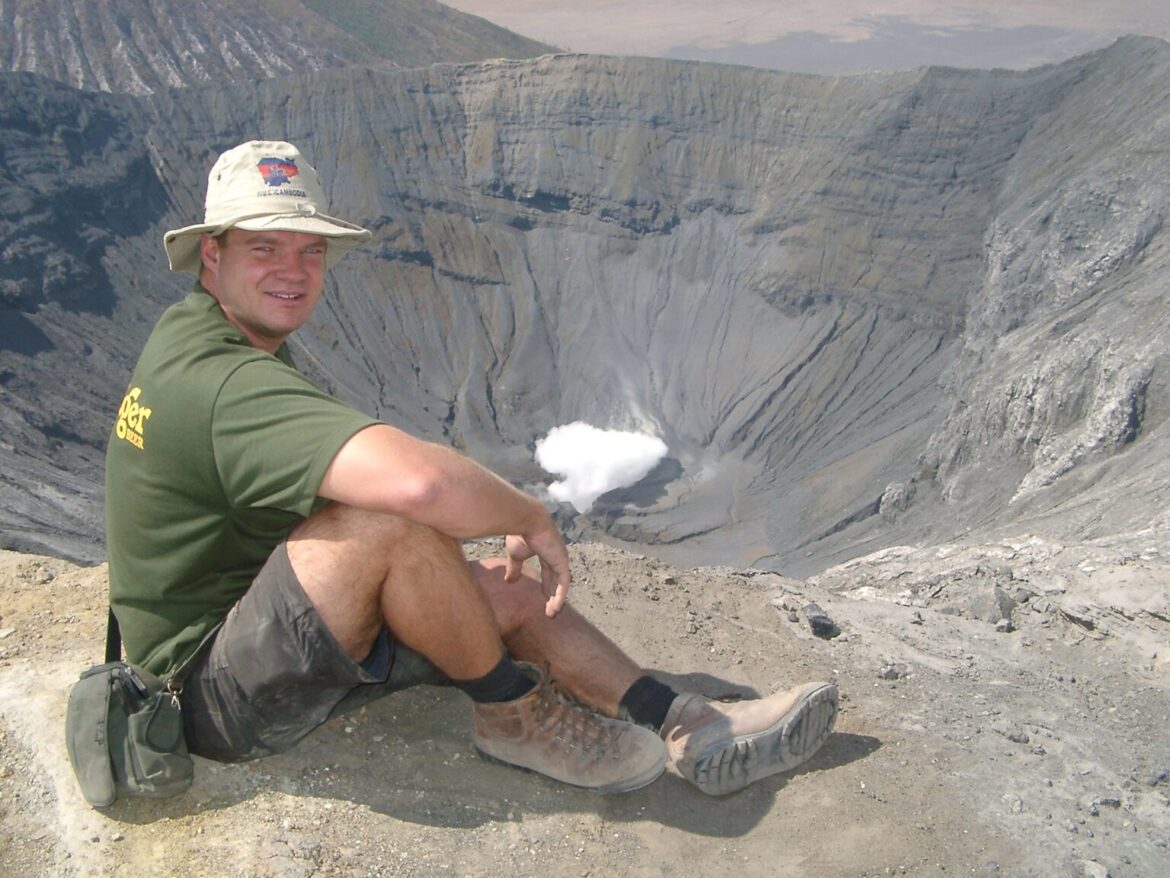 Alan sitting beside the crater of Mount Bromo in Indonesia